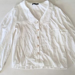 White long-sleeved blouse with ruffle collar